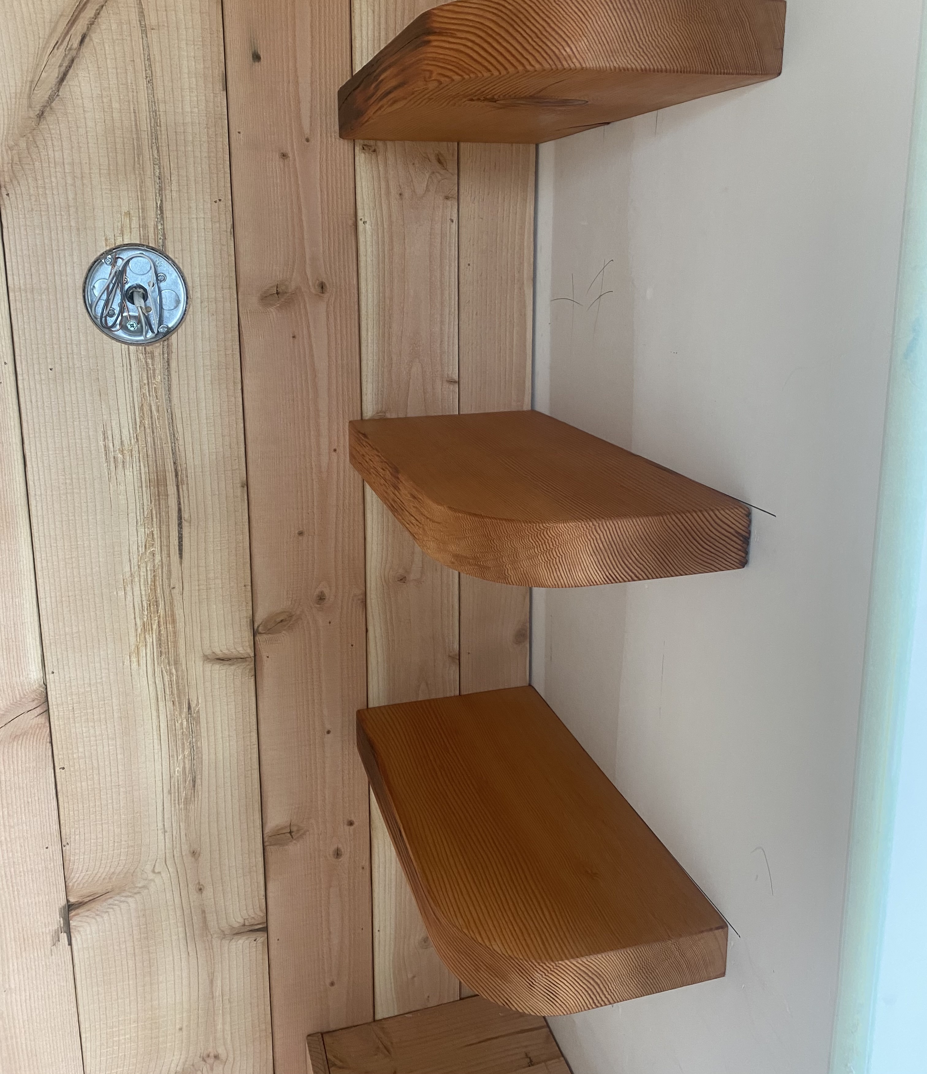 A wooden shelf in a corner of a room