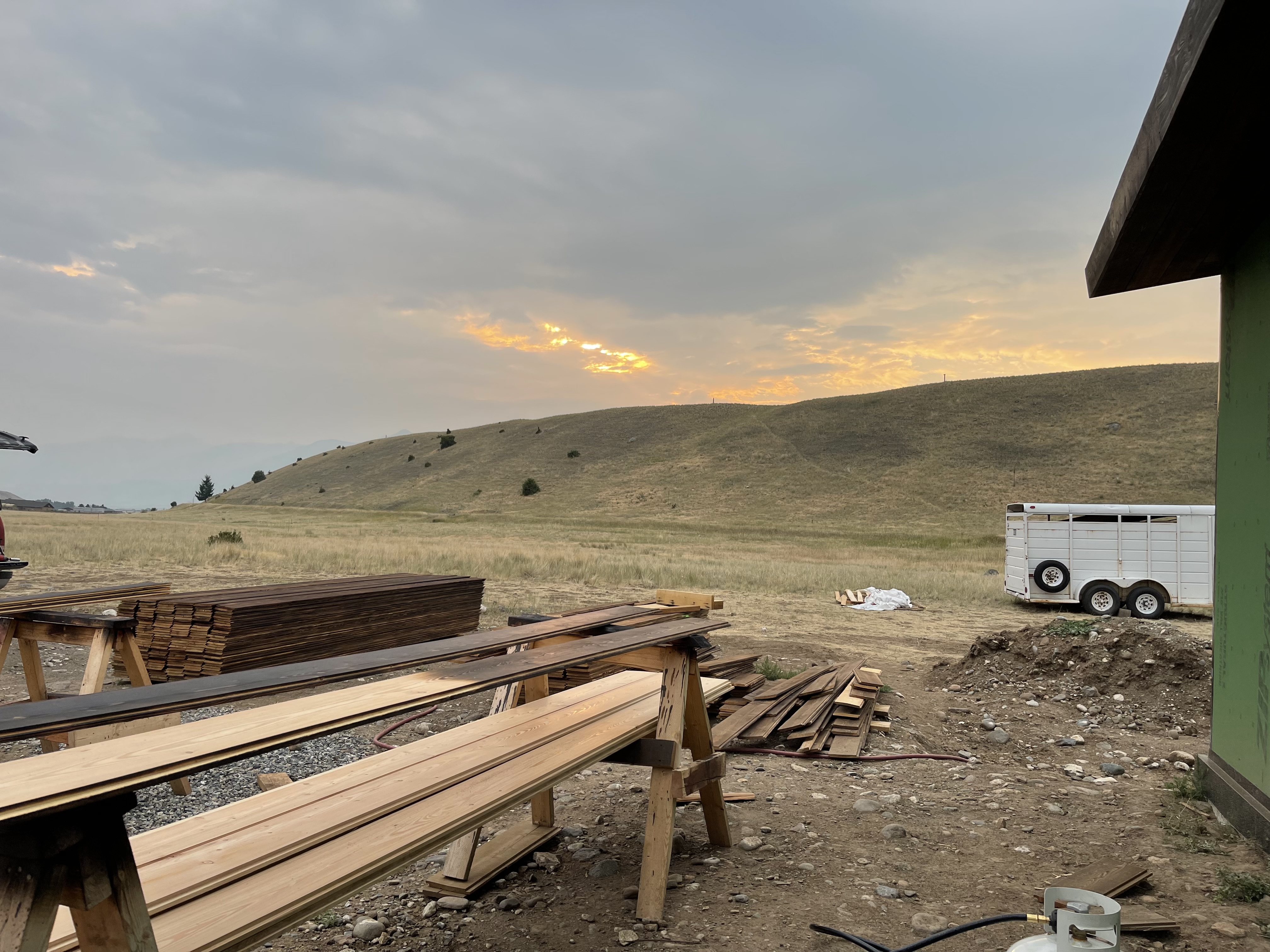 A couple of wooden benches sitting on top of a dirt field