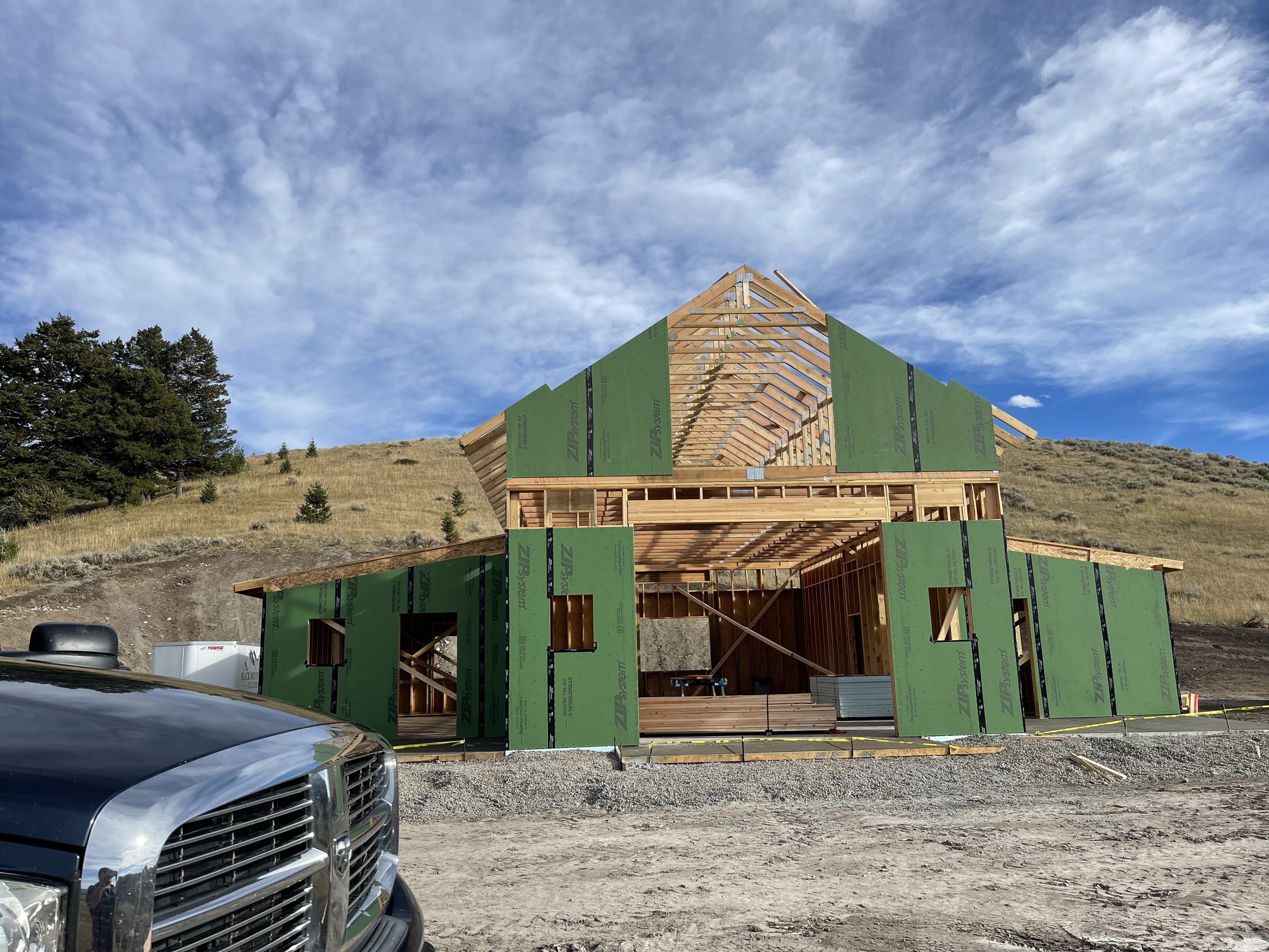 A truck is parked in front of a house under construction