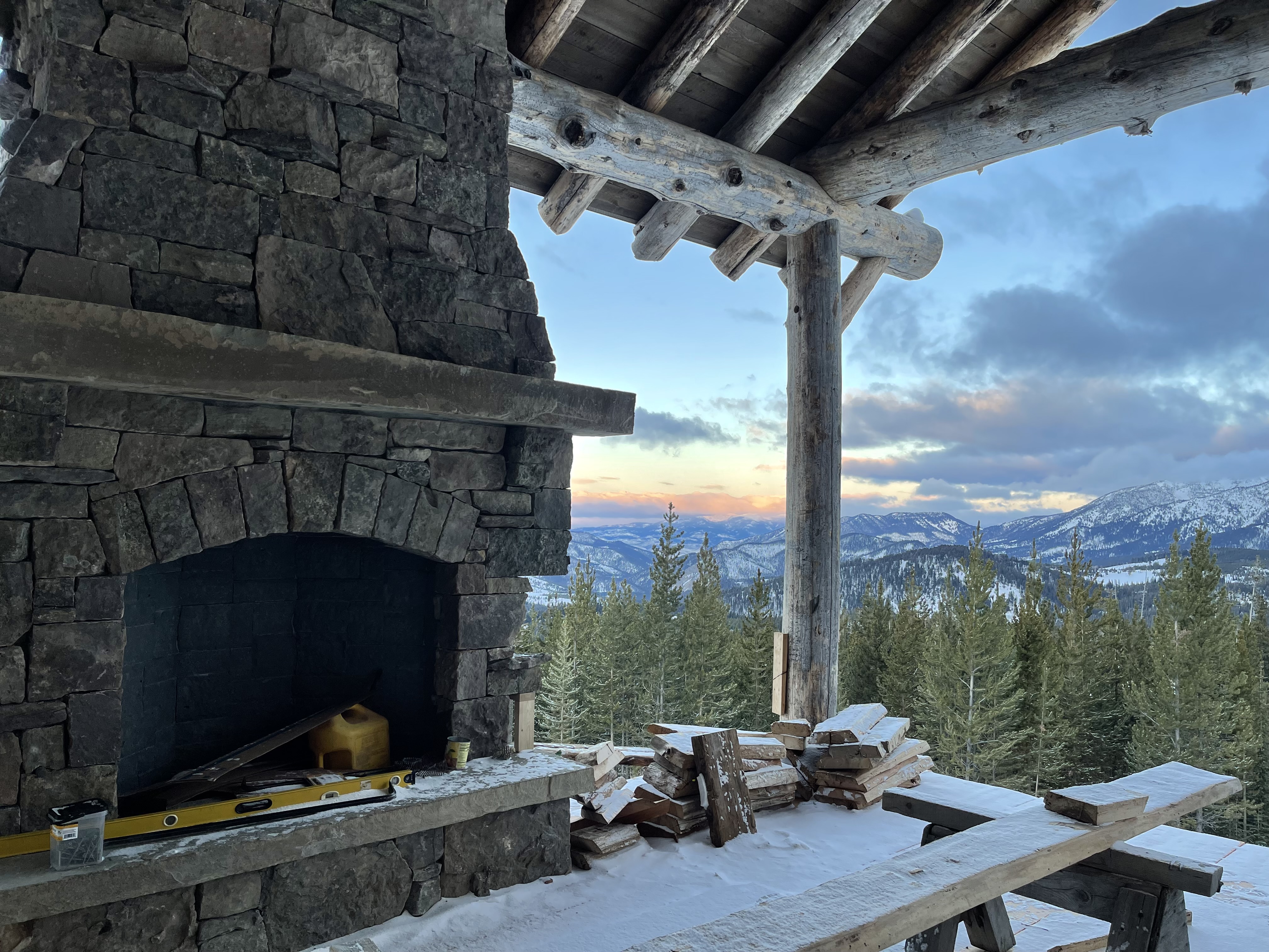 A stone fireplace with a view of the mountains