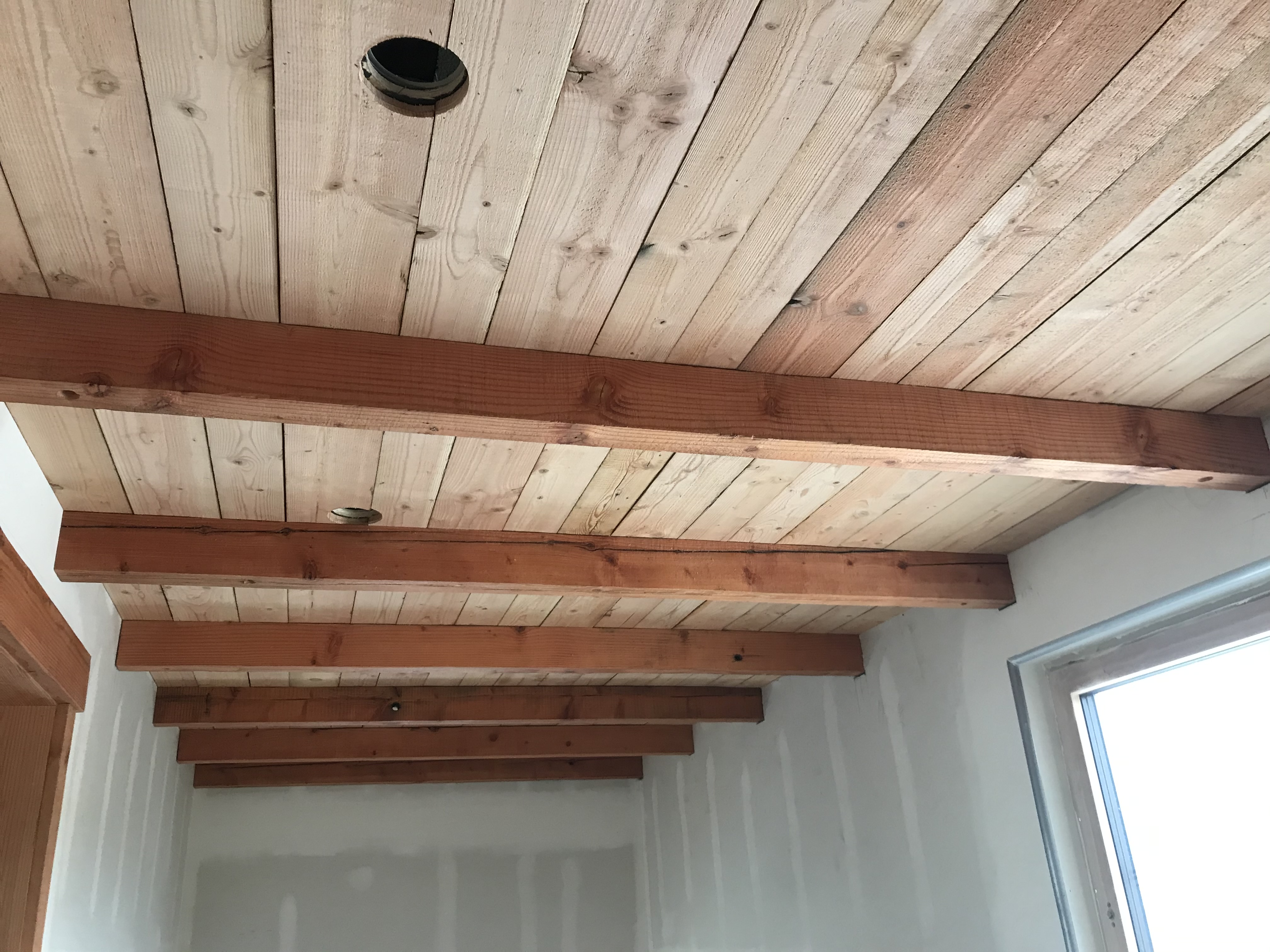 A room with a ceiling made of wood planks