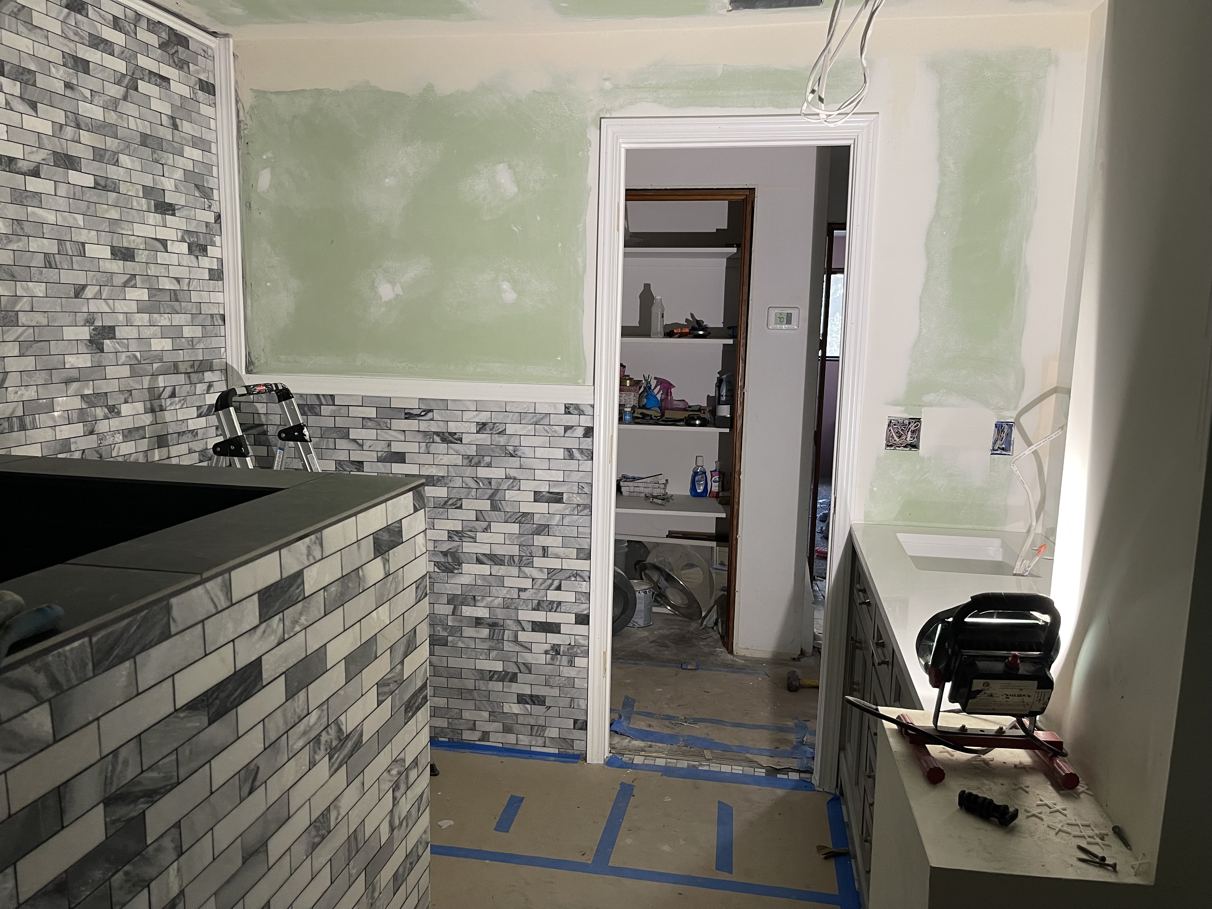 A bathroom with a sink and a tiled wall