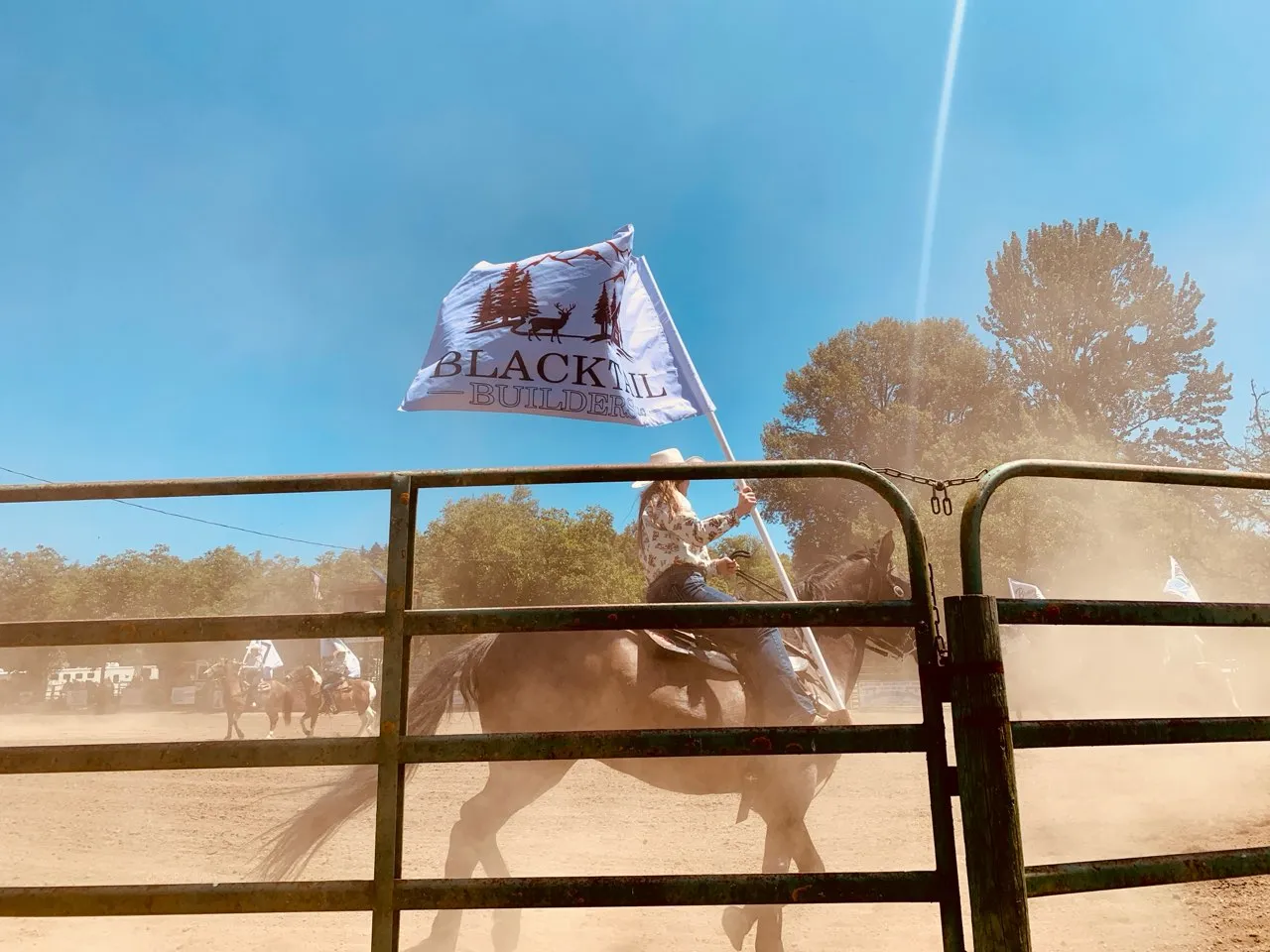 Blacktail Builders team member on horseback with company flag