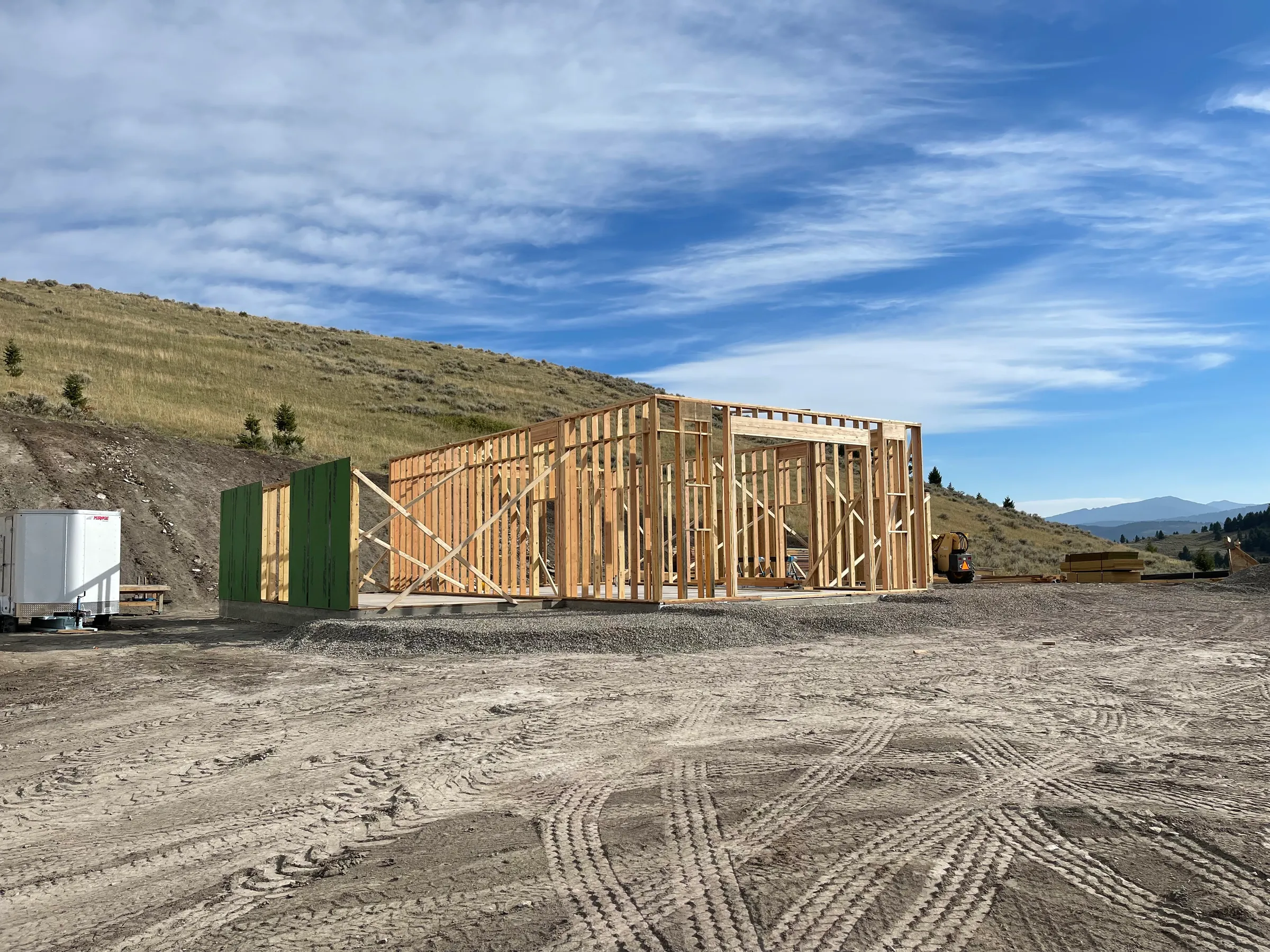 Home framing on a hillside with mountain backdrop