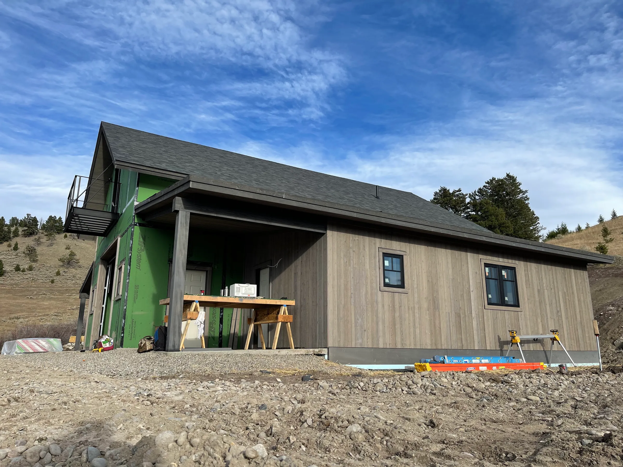 Modern farmhouse under construction on hillside