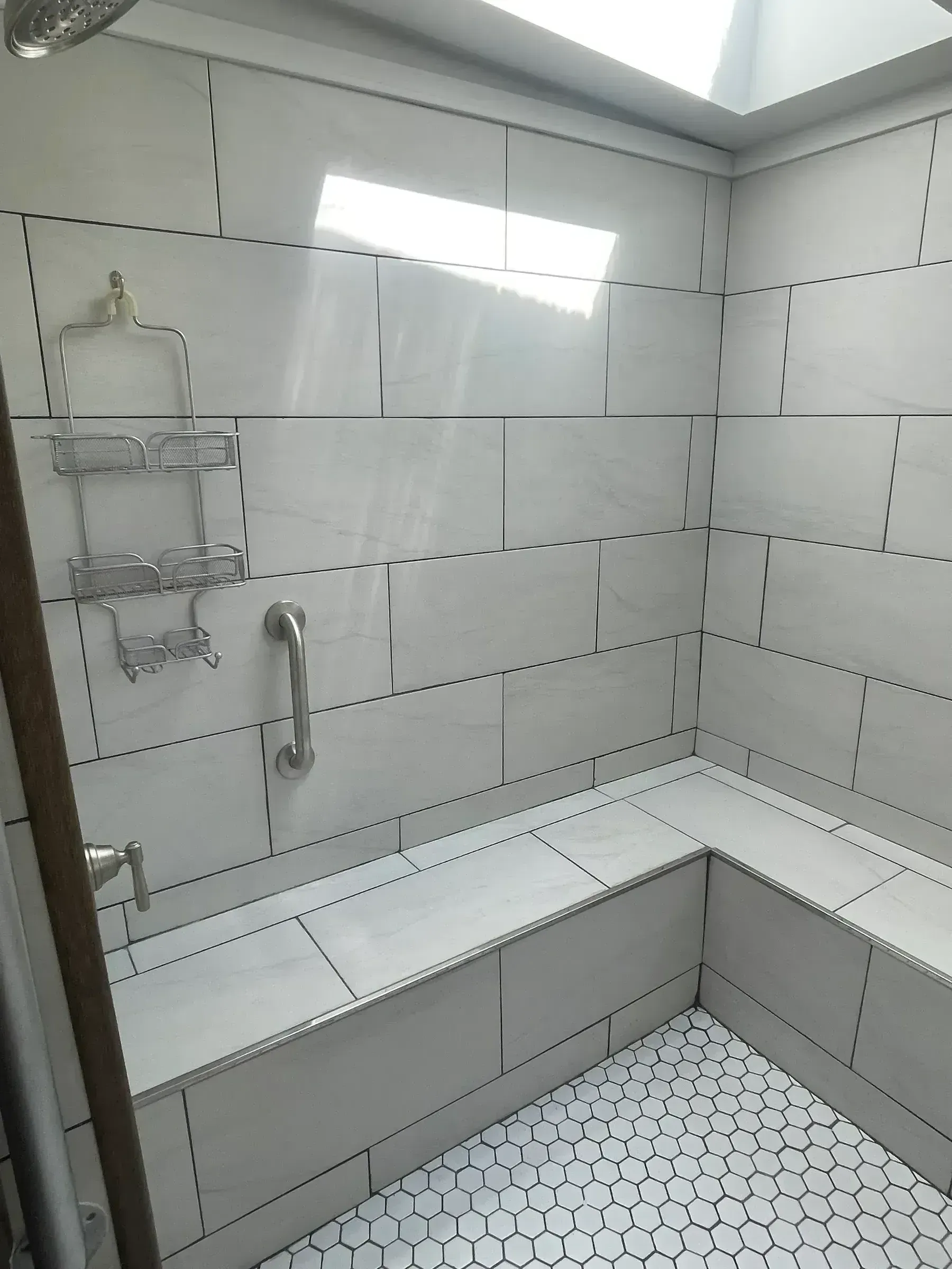 Tiled shower with marble-look tile and hexagonal accent