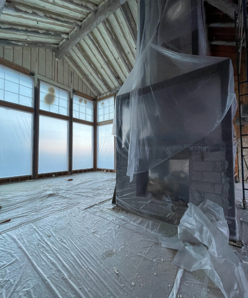 A room with a large window and a sheet of plastic on the floor